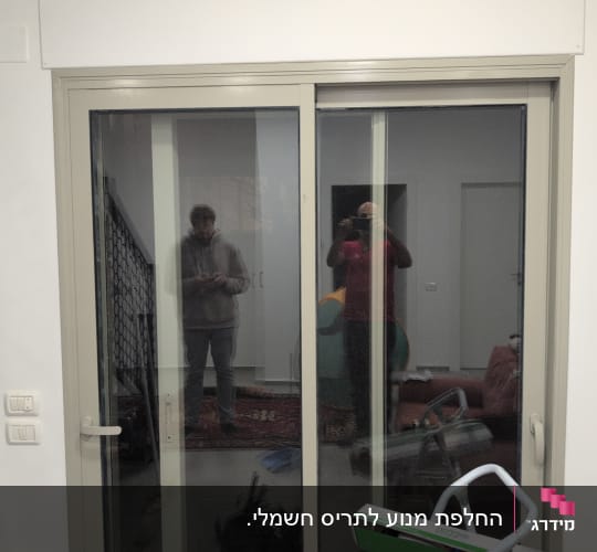 דלת הזזה מזכוכית עם השתקפות אנשים